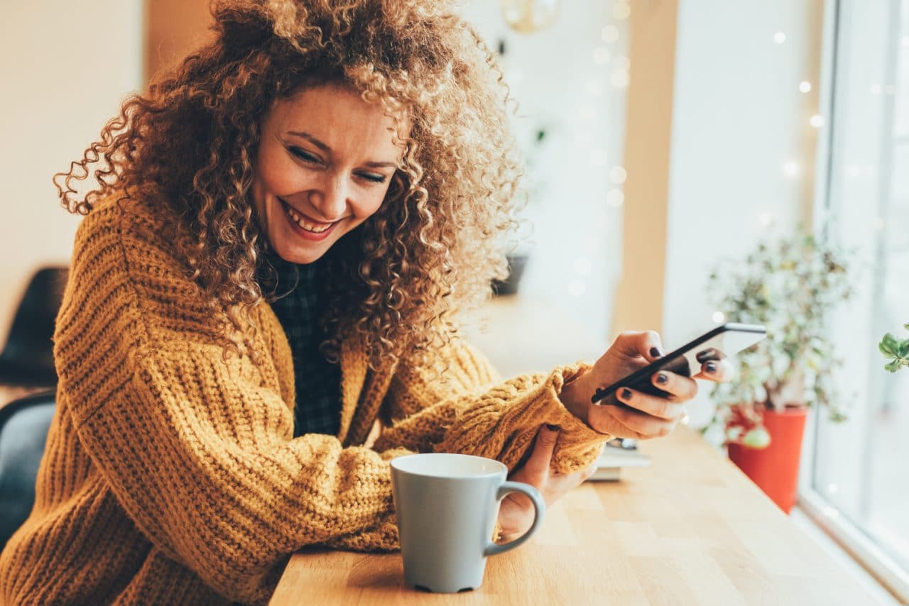 A person holding their phone and laughing
