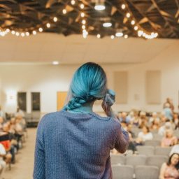 Woman speaking in front of crowd.
