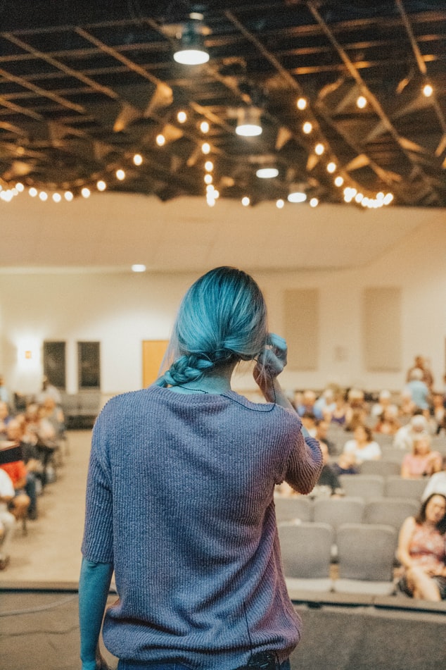 Woman speaking in front of crowd.