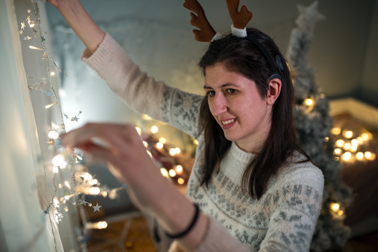 Woman wearing a hearing aid decorating for the holidays.