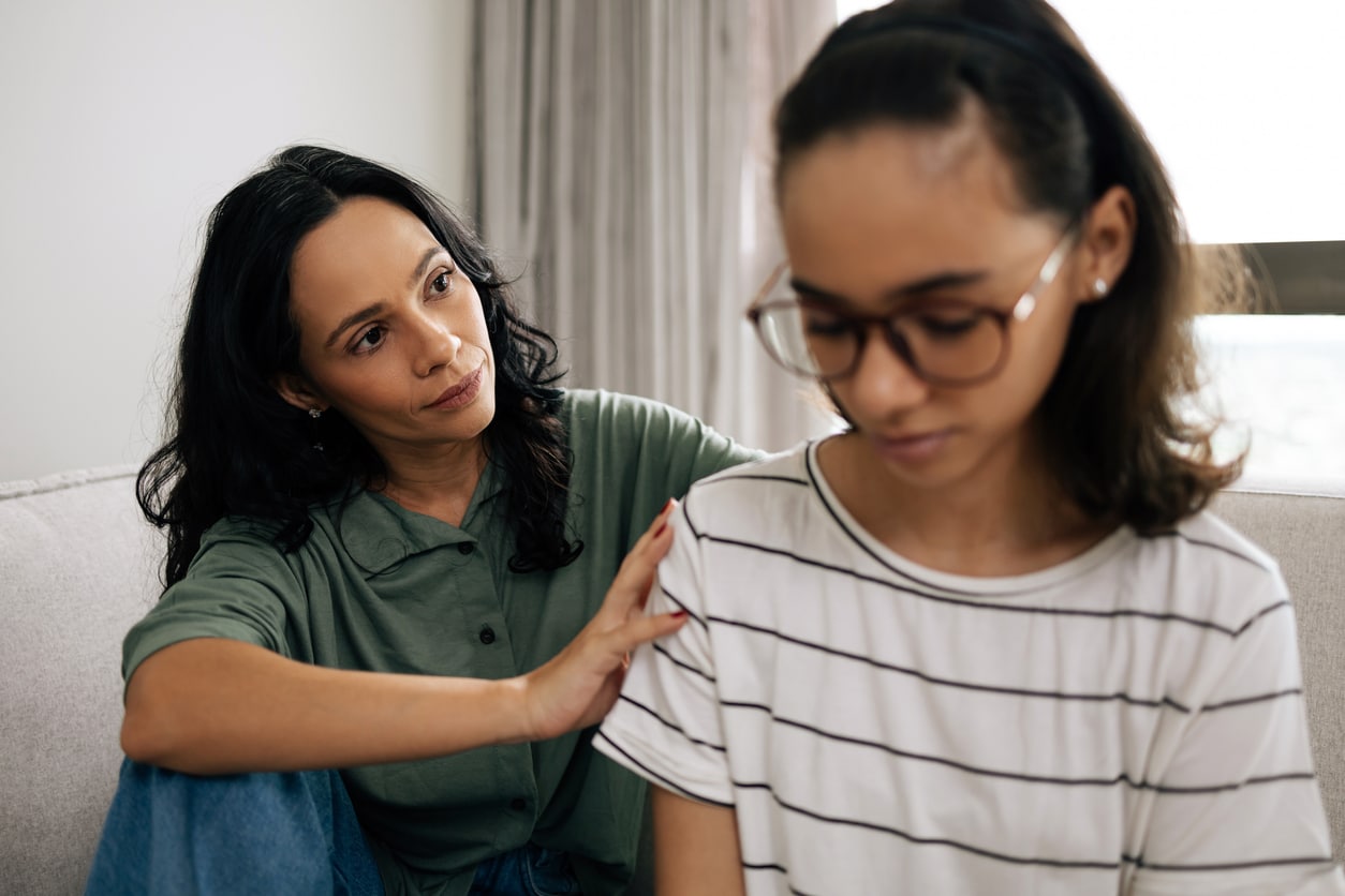 Mom and teenager daughter having an emotional talk.