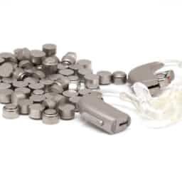 Hearing aids sitting next to a pile of batteries