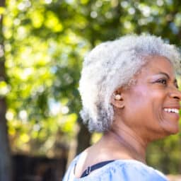 Senior woman smiling, showing off her hearing aid