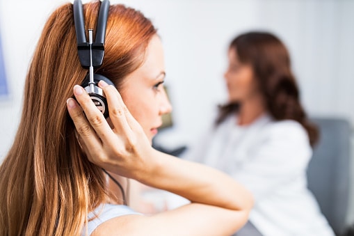 Woman putting on headphones for a hearing test.