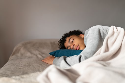 Teenager sleeping in his bedroom.